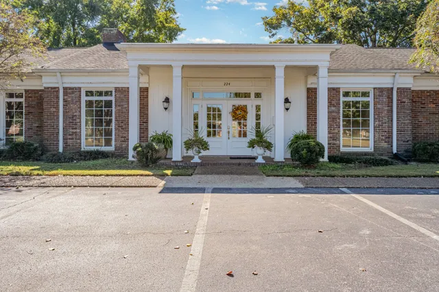 a view of a white house with a large windows and plants