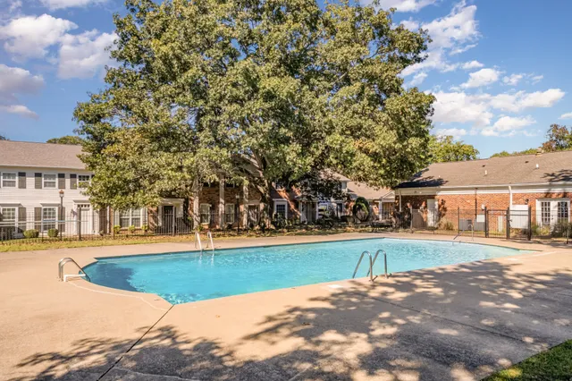 a view of a white house with a big yard and large trees