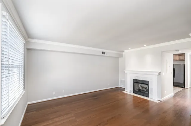 an empty room with wooden floor and fireplace