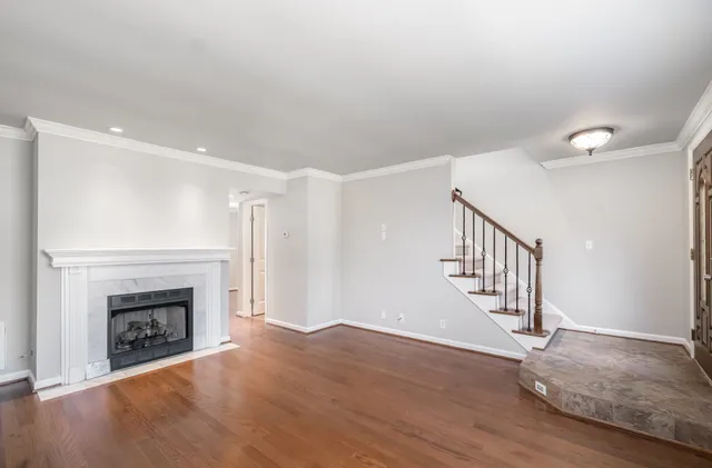 a view of empty room with wooden floor and fireplace