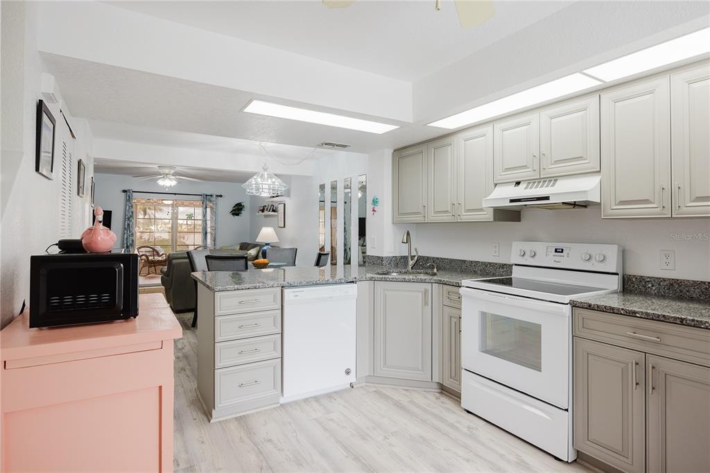 26282 Rampart Boulevard, Unit 204 Punta Gorda, FL 33983 - Photo 9 of 34 a kitchen with white cabinets and white appliances
