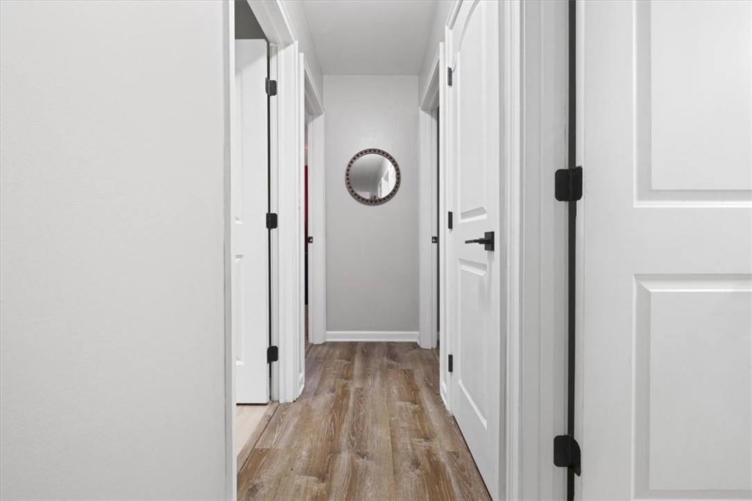 1482 Lee Road Troy, OH 45373 - Photo 8 of 30 This interior hallway features beautiful wood flooring and bright white doors leading to various rooms.