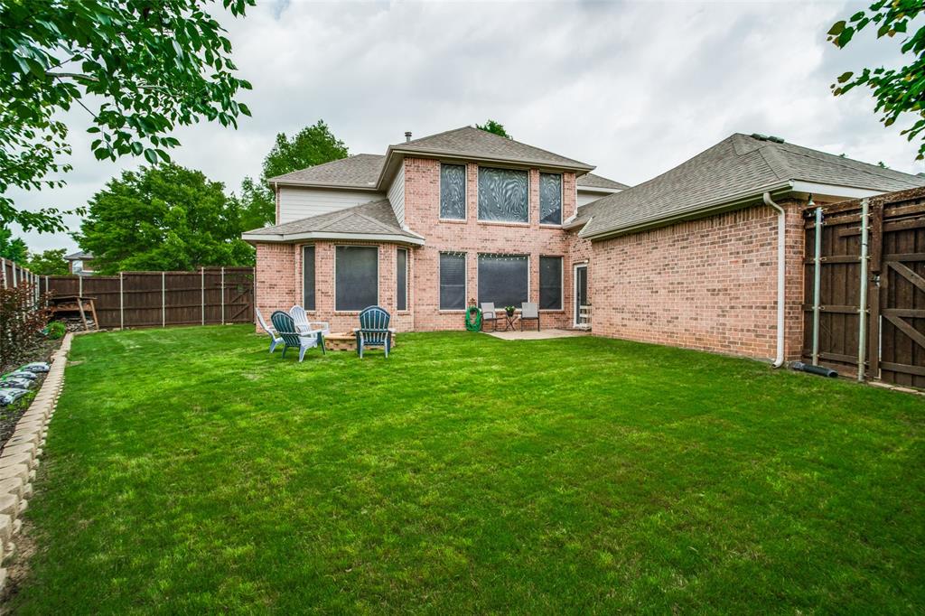 1612 Coventry Lane Allen, TX 75002 - Photo 32 of 39 Expansive fenced backyard featuring a manicured lawn, brick paver edging, and a concrete patio