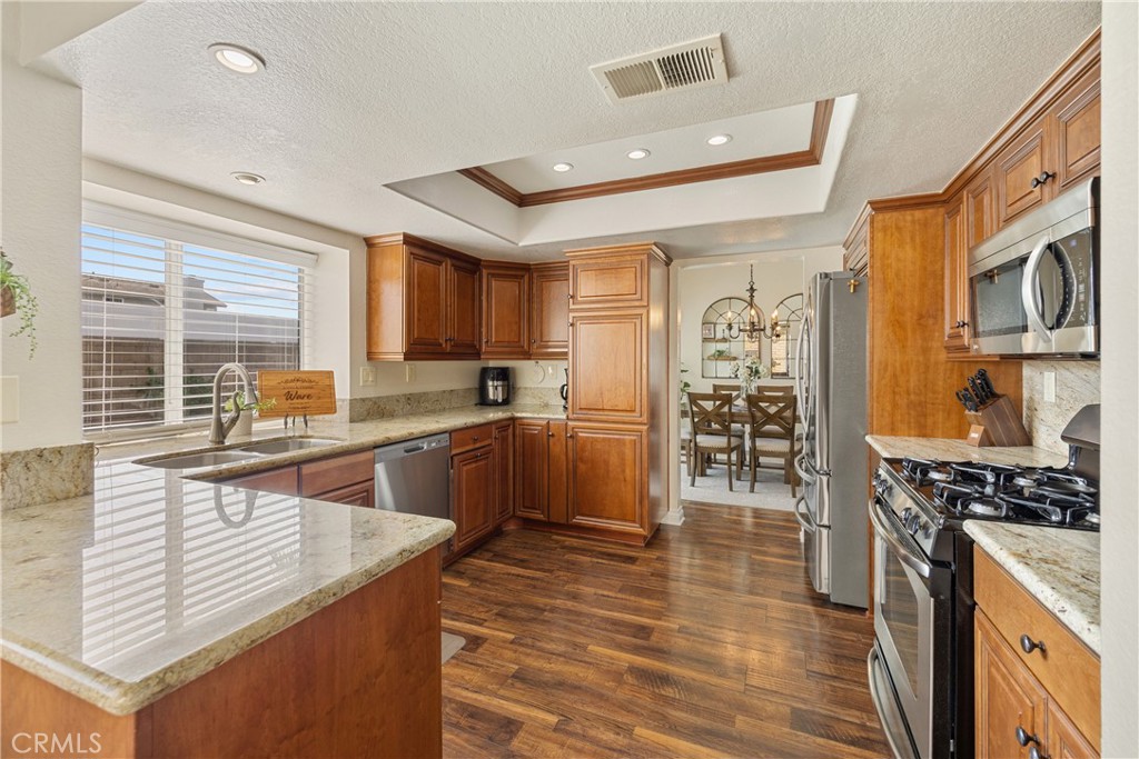 7051 Stanislaus Place Rancho Cucamonga, CA 91701 - Photo 21 of 57 a kitchen with stainless steel appliances granite countertop a stove a sink and a refrigerator