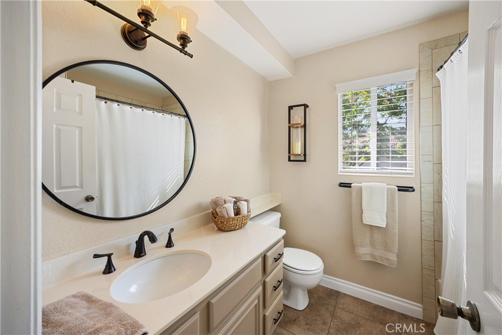 7051 Stanislaus Place Rancho Cucamonga, CA 91701 - Photo 29 of 57 a bathroom with a granite countertop toilet sink and mirror