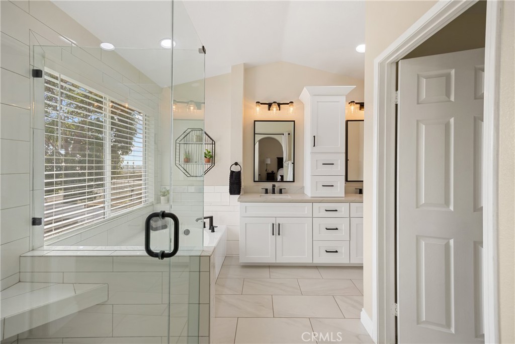 7051 Stanislaus Place Rancho Cucamonga, CA 91701 - Photo 33 of 57 a bathroom with a granite countertop sink a mirror and a shower
