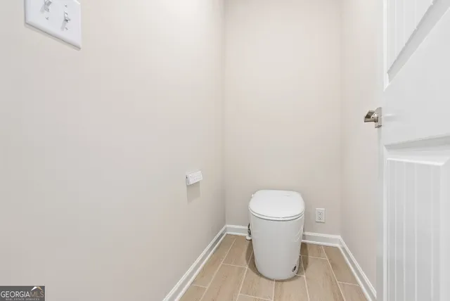 a white toilet sitting next to a white wall