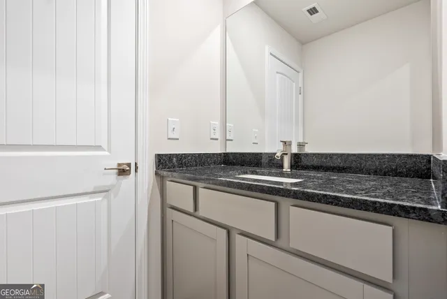a kitchen with stainless steel appliances granite countertop a sink and a white cabinets