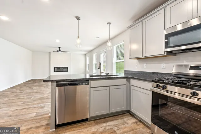 a kitchen with granite countertop a sink stainless steel appliances and cabinets