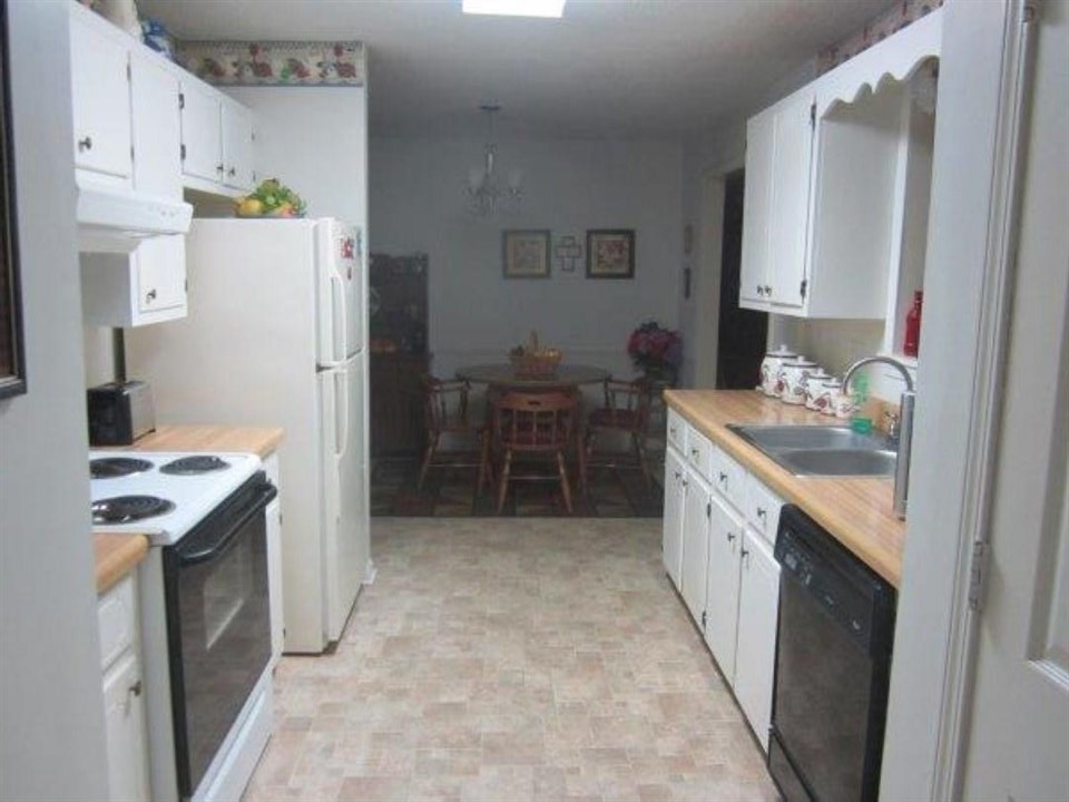 1741 Conner Whitefield Road Ripley, TN 38063 - Photo 14 of 24 a kitchen with a sink a stove a refrigerator and cabinets