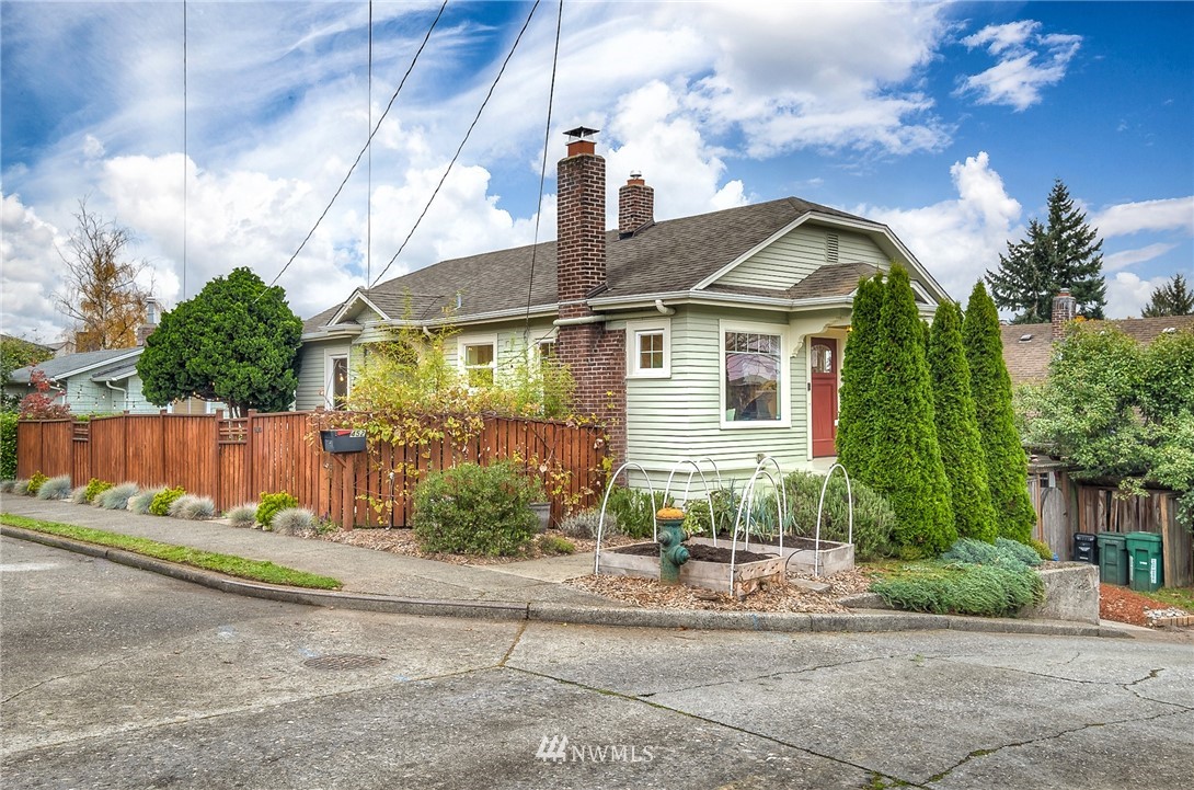 a front view of a house with a yard and potted plants