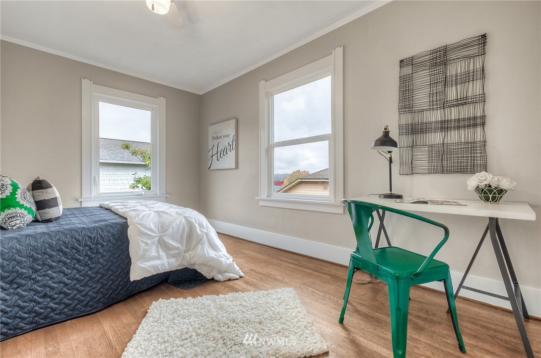 452 North 65th Street Seattle, WA 98103 - Photo 12 of 31 a bedroom with a bed a table and chair with wooden floor