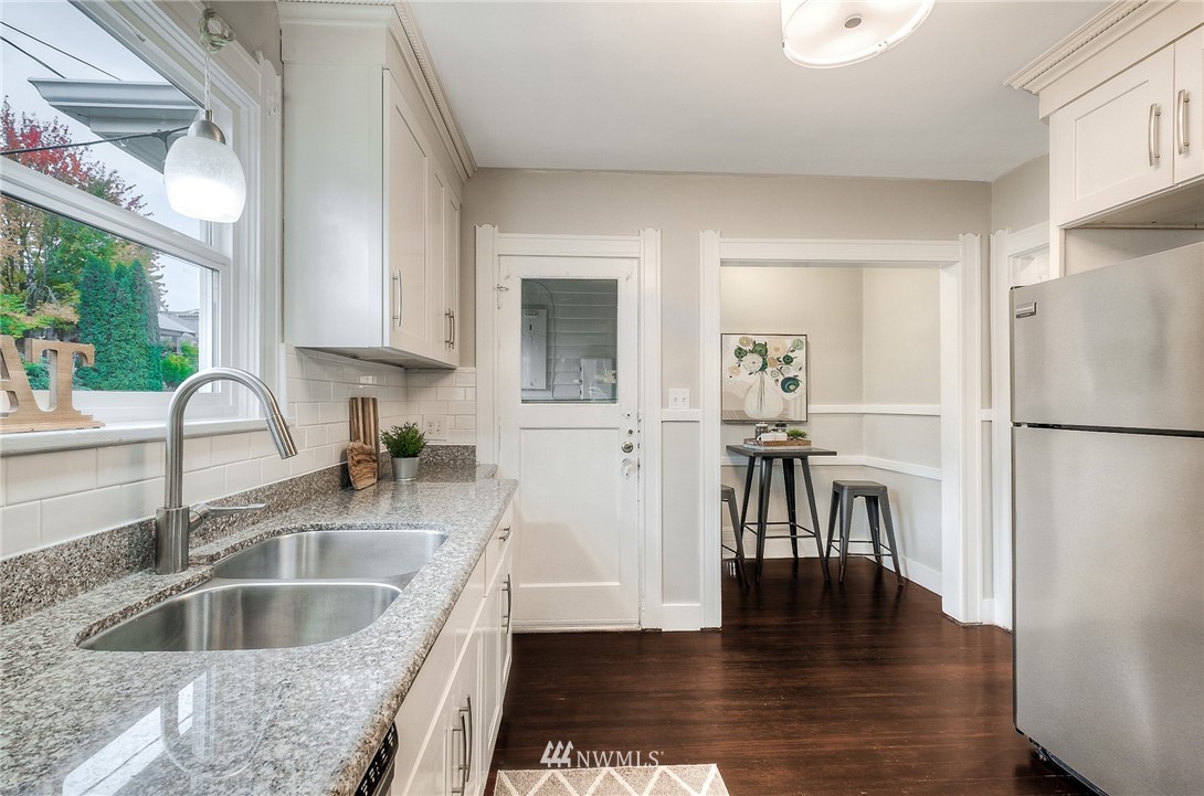 452 North 65th Street Seattle, WA 98103 - Photo 17 of 31 a kitchen with stainless steel appliances granite countertop a refrigerator a stove and a sink with granite countertops