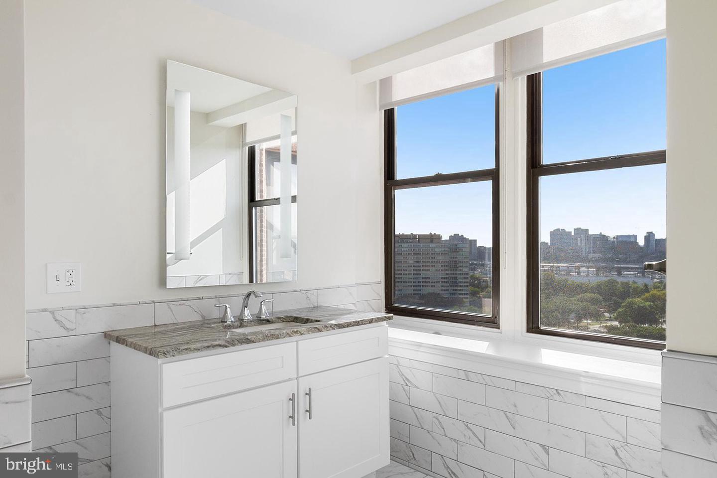 2201 Pennsylvania Avenue, Unit 1204B Philadelphia, PA 19130 - Photo 15 of 46 a bathroom with a granite countertop sink and a large mirror