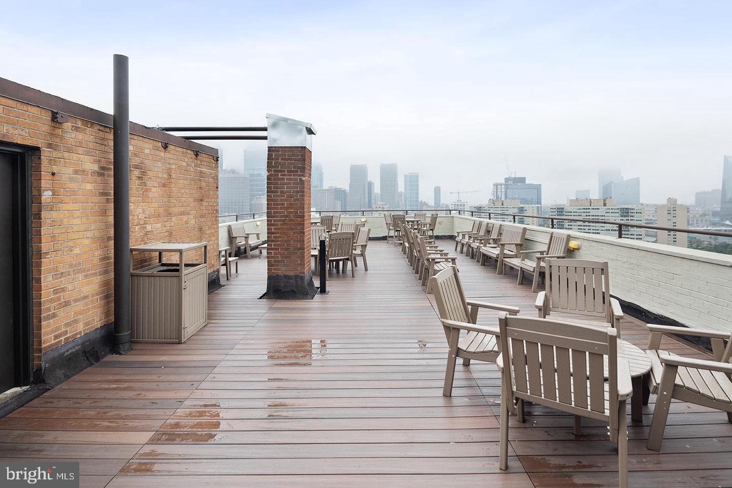 2201 Pennsylvania Avenue, Unit 1204B Philadelphia, PA 19130 - Photo 34 of 46 a view of a rooftop deck with chairs and wooden floor