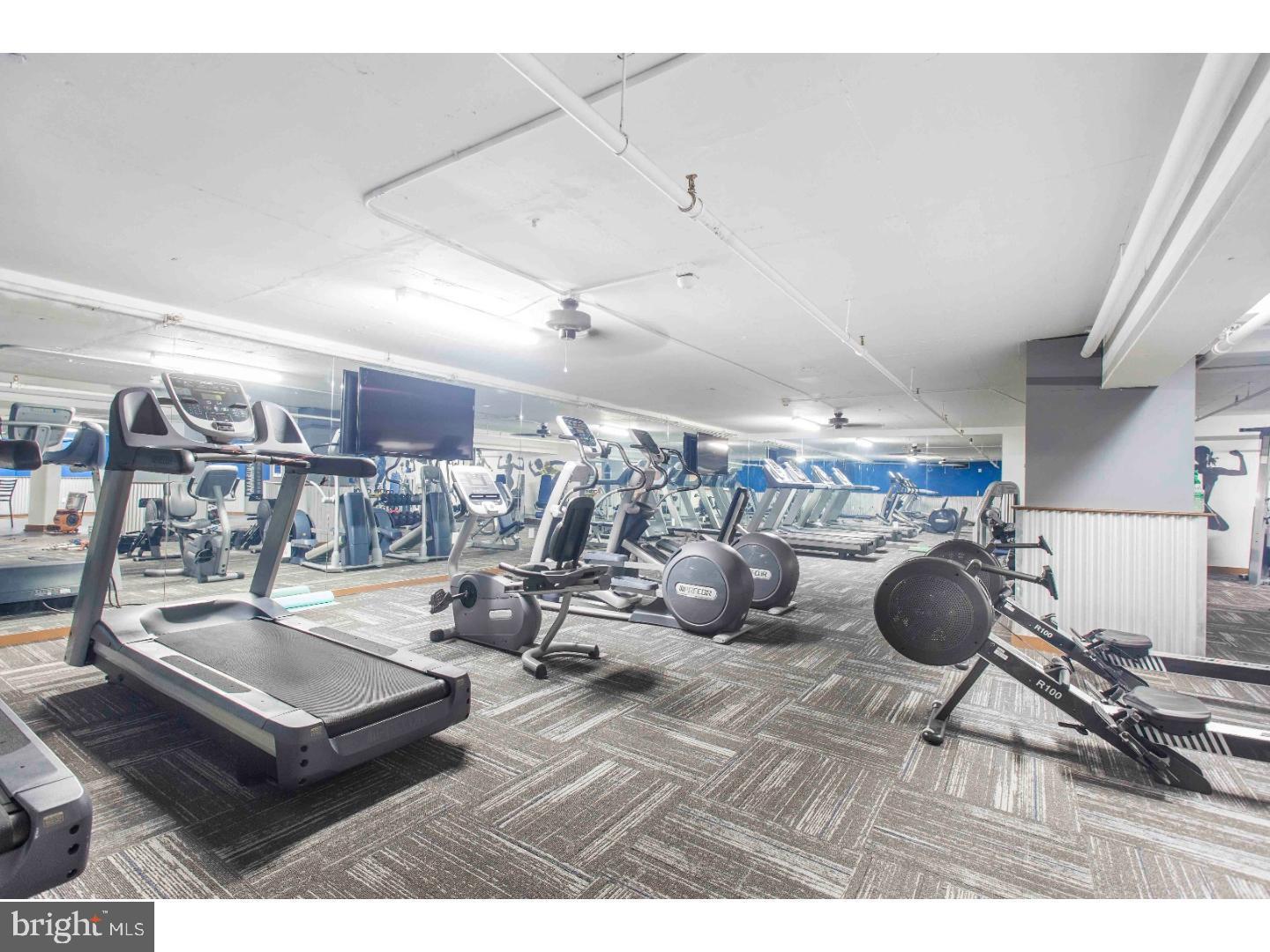 2201 Pennsylvania Avenue, Unit 1204B Philadelphia, PA 19130 - Photo 43 of 46 a living room with lots of furniture and gym equipment