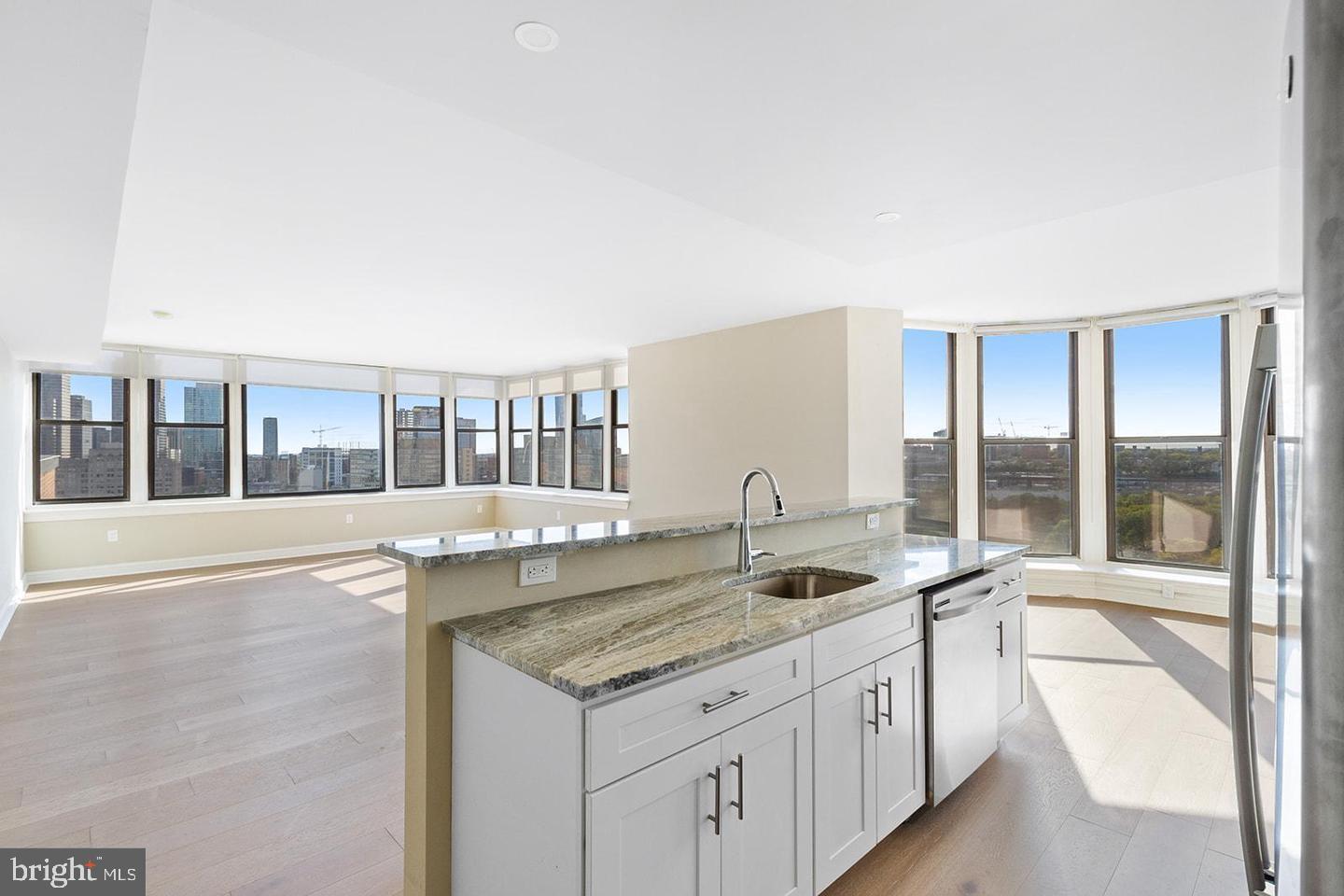 2201 Pennsylvania Avenue, Unit 1204B Philadelphia, PA 19130 - Photo 7 of 46 a kitchen with granite countertop a sink and a large window