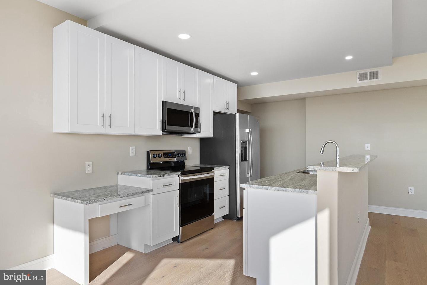 2201 Pennsylvania Avenue, Unit 1204B Philadelphia, PA 19130 - Photo 8 of 46 a kitchen with a sink a stove and refrigerator