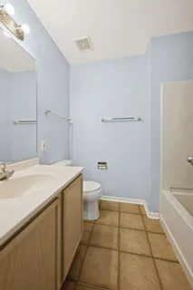 a bathroom with a granite countertop sink a toilet and a bathtub