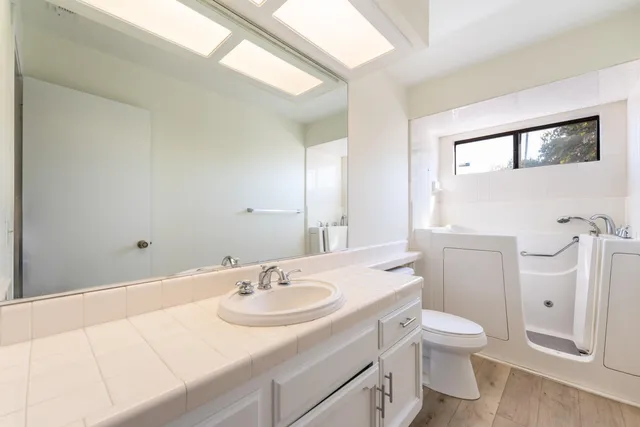 a bathroom with a sink toilet and mirror