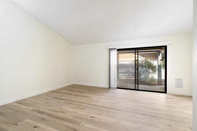 an empty room with wooden floor and outdoor view