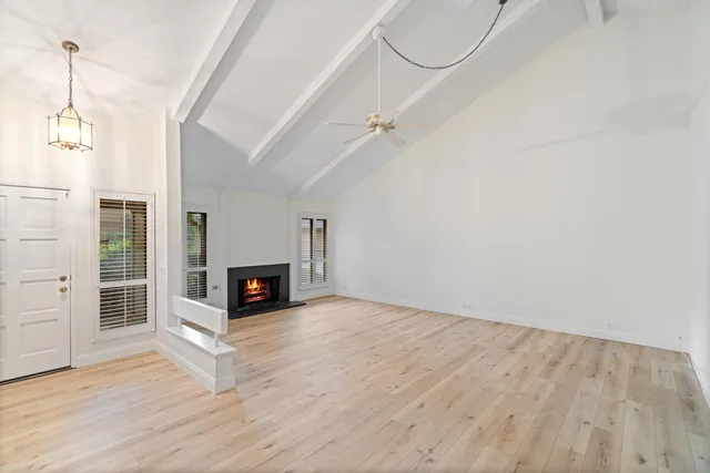 a view of a livingroom with wooden floor a fireplace and entryway