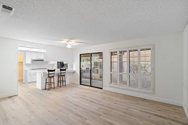 a view of a kitchen with furniture and wooden floor