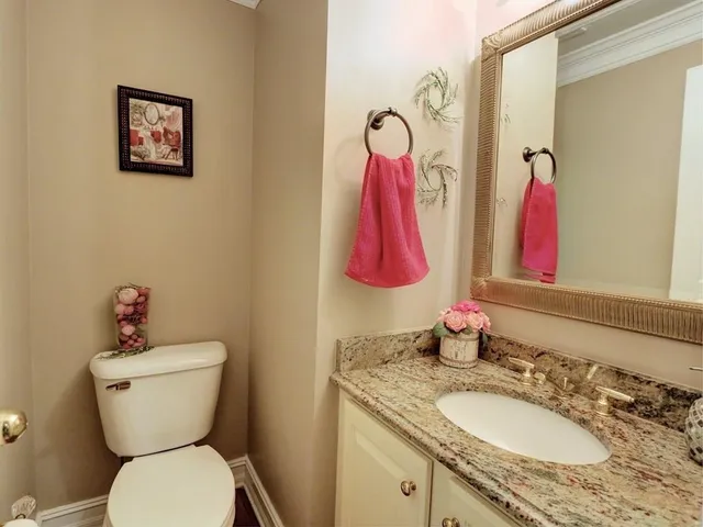 a bathroom with a granite countertop toilet sink and a mirror