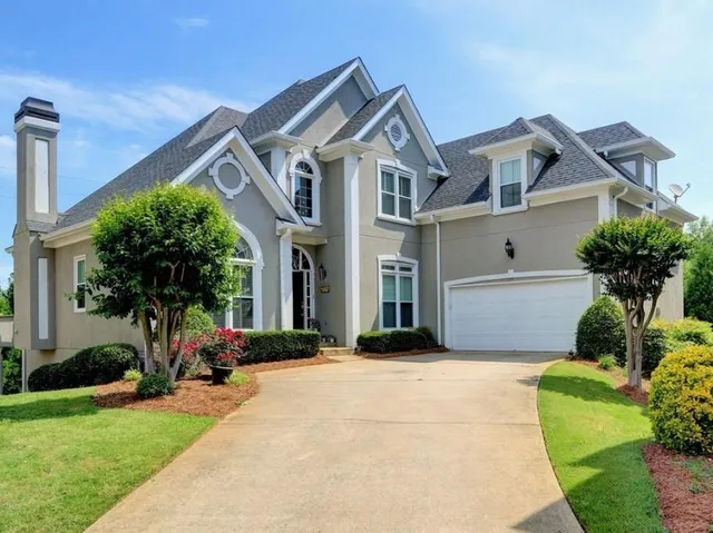 a front view of a house with a yard and potted plants