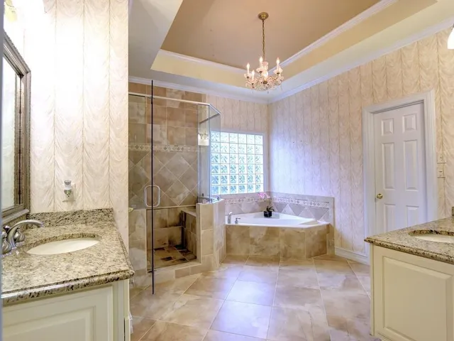 a spacious bathroom with a granite countertop tub sink and mirror