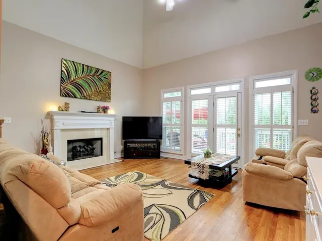 a living room with furniture large window and a fireplace