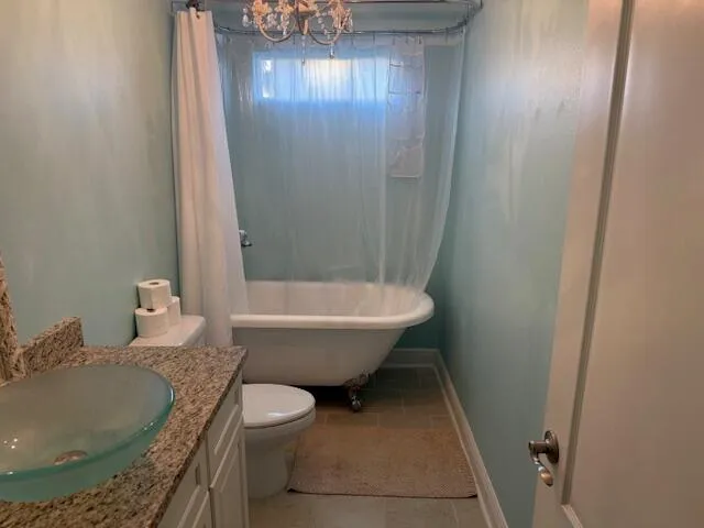 a bathroom with a granite countertop sink and a toilet