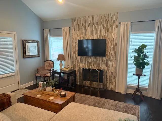 a living room with furniture a fireplace and a flat screen tv