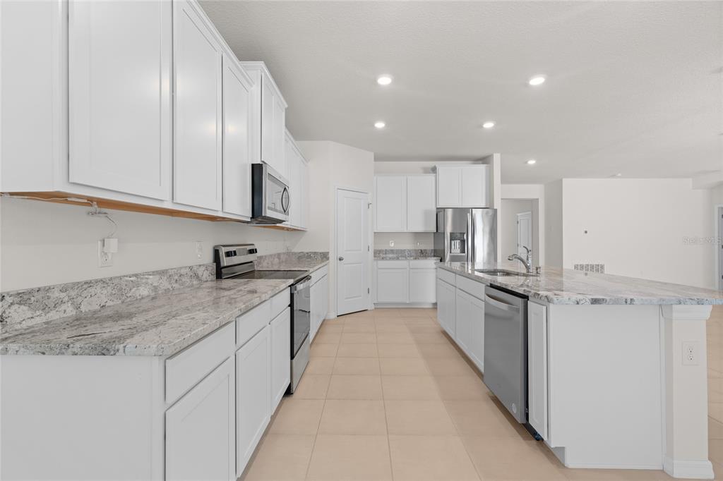 8260 Southwest 59th Avenue Ocala, FL 34476 - Photo 4 of 20 a large kitchen with stainless steel appliances granite countertop a sink and cabinets