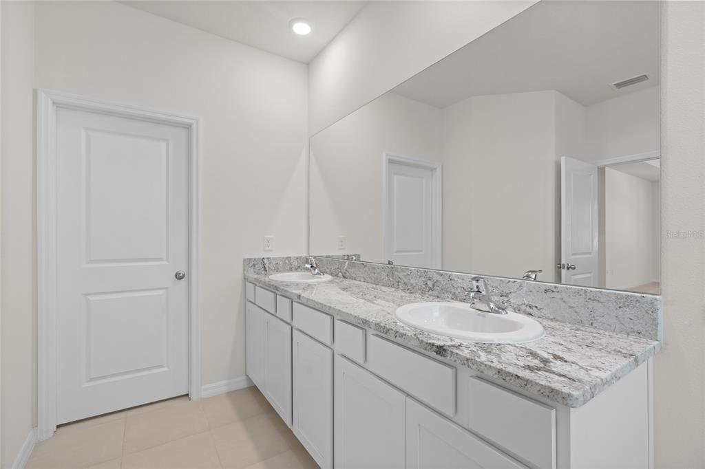 8260 Southwest 59th Avenue Ocala, FL 34476 - Photo 5 of 20 a bathroom with a granite countertop sink and a mirror