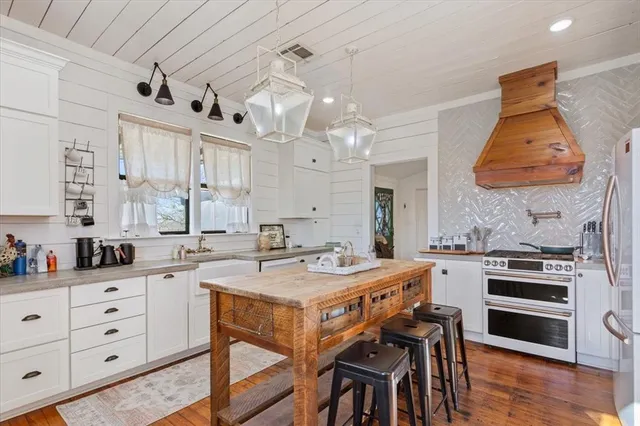 a kitchen with a table chairs stove and cabinets