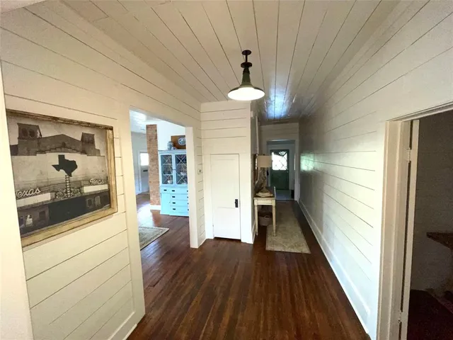 a view of a hallway view with wooden floor and chandelier