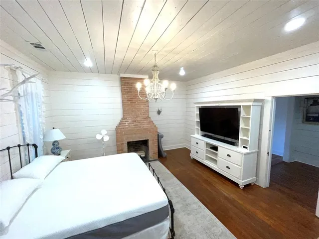 a bedroom with a bed and a flat tv screen on wall
