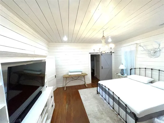 a large bedroom with a bed and a chandelier