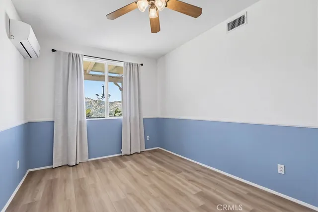 a kitchen with kitchen island a stove a refrigerator a sink and white cabinets with wooden floor