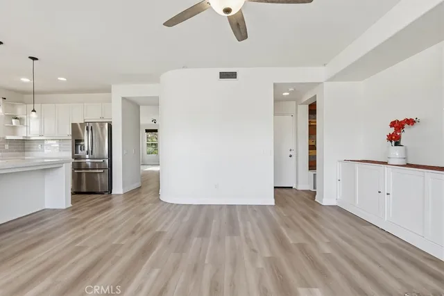 a kitchen with granite countertop a stove and white cabinets with wooden floor