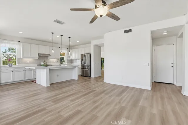 a large kitchen with kitchen island white cabinets and stainless steel appliances