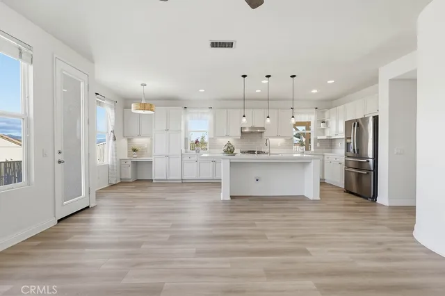 a large kitchen with stainless steel appliances granite countertop a stove a sink dishwasher and a refrigerator