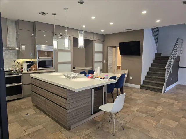 a kitchen with kitchen island a sink a counter top stainless steel appliances and cabinets