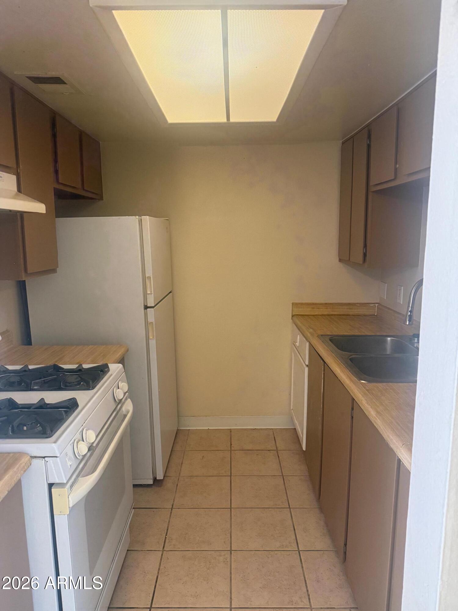 1622 East Campbell Avenue, Unit R Phoenix, AZ 85016 - Photo 4 of 15 a kitchen with a stove top oven and cabinets