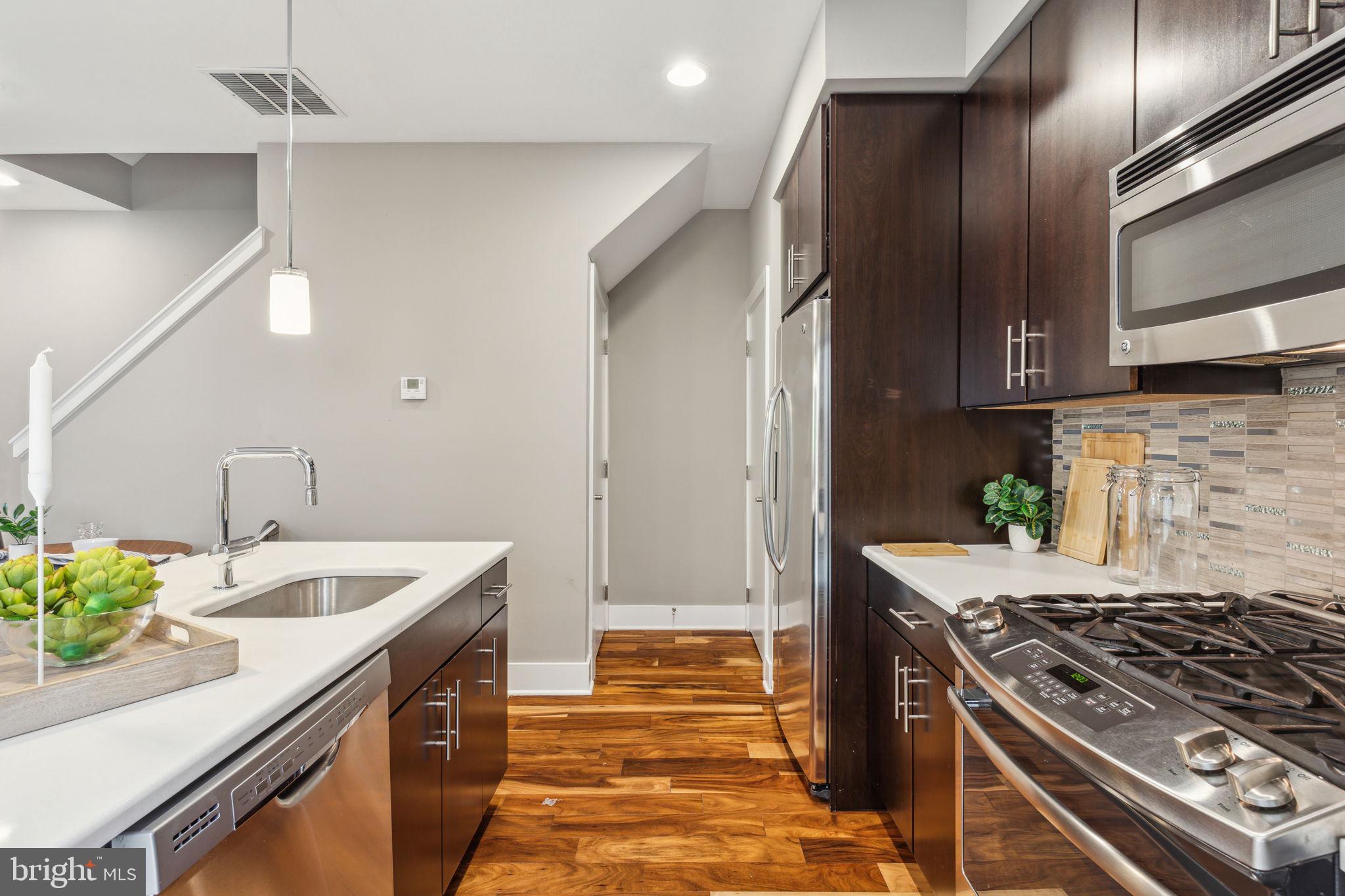 832 North 3rd Street, Unit 7 Philadelphia, PA 19123 - Photo 19 of 52 a kitchen with granite countertop a sink stainless steel appliances a counter space and cabinets