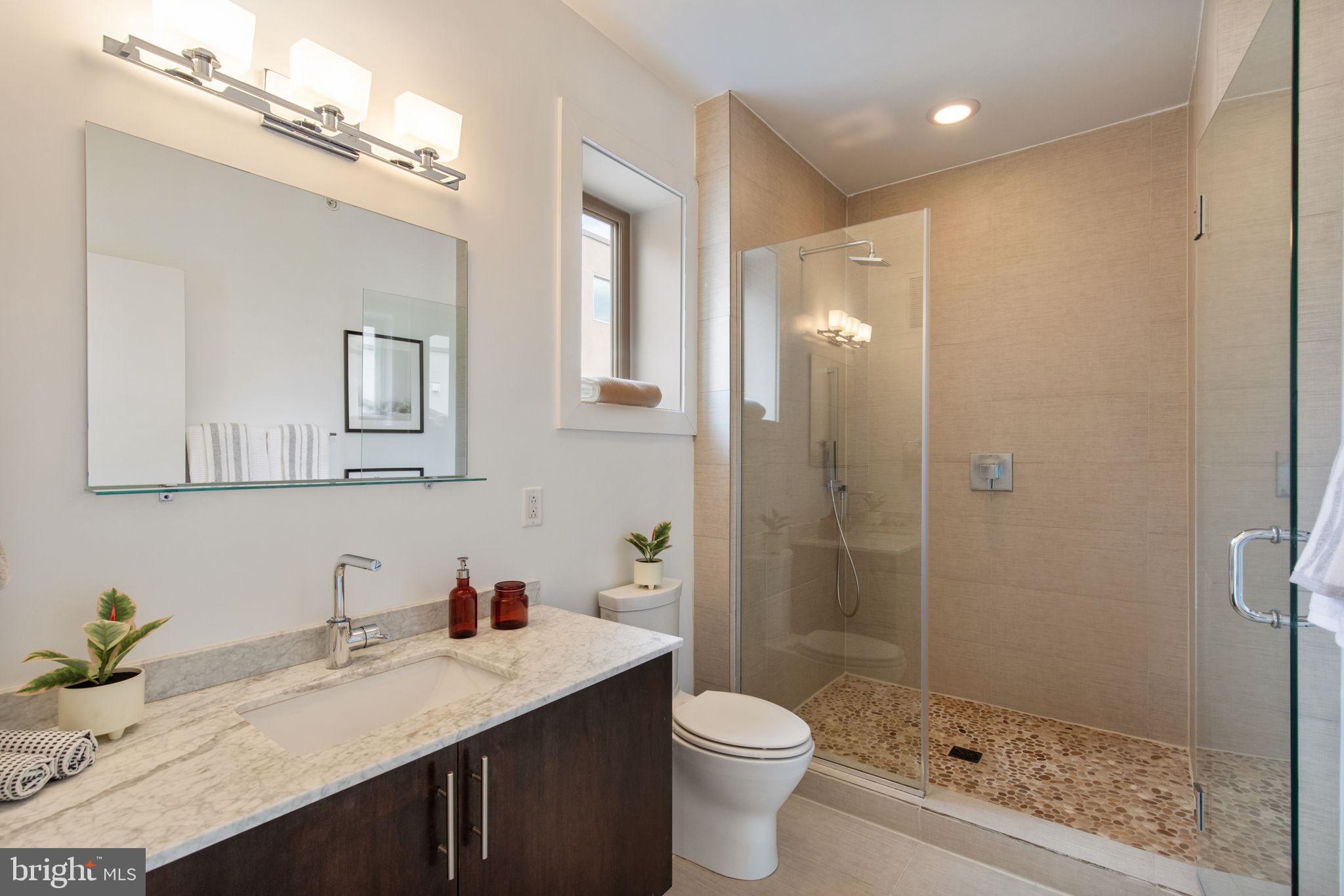 832 North 3rd Street, Unit 7 Philadelphia, PA 19123 - Photo 40 of 52 a bathroom with a granite countertop sink toilet a mirror a vanity and shower
