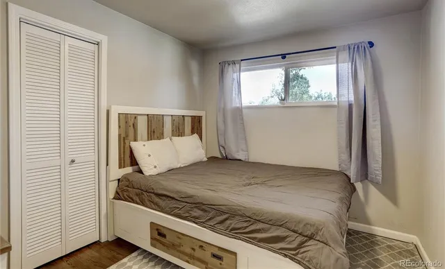 a bed sitting in a bedroom next to a window