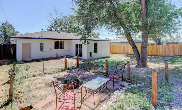 a view of a house with backyard and sitting area