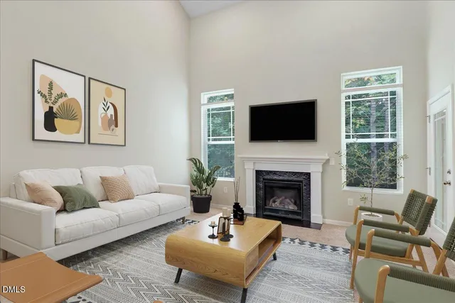 a living room with furniture a flat screen tv and a fireplace
